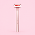 A handheld beauty device with a metallic rose gold handle and a head featuring a row of red LED light dots, shown against a solid light pink background.